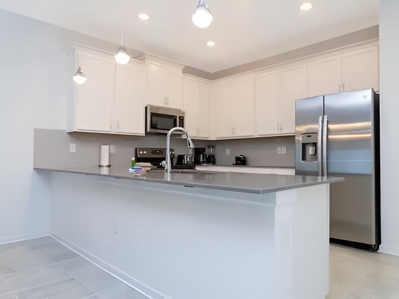 Modern fully-equipped kitchen with stainless steel appliances.