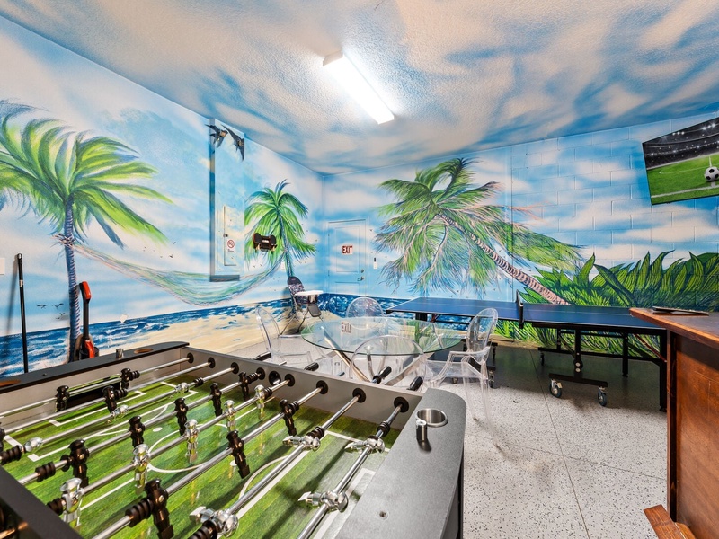 Featuring a foosball table, ping-pong table, TV and mini bar fridge.
