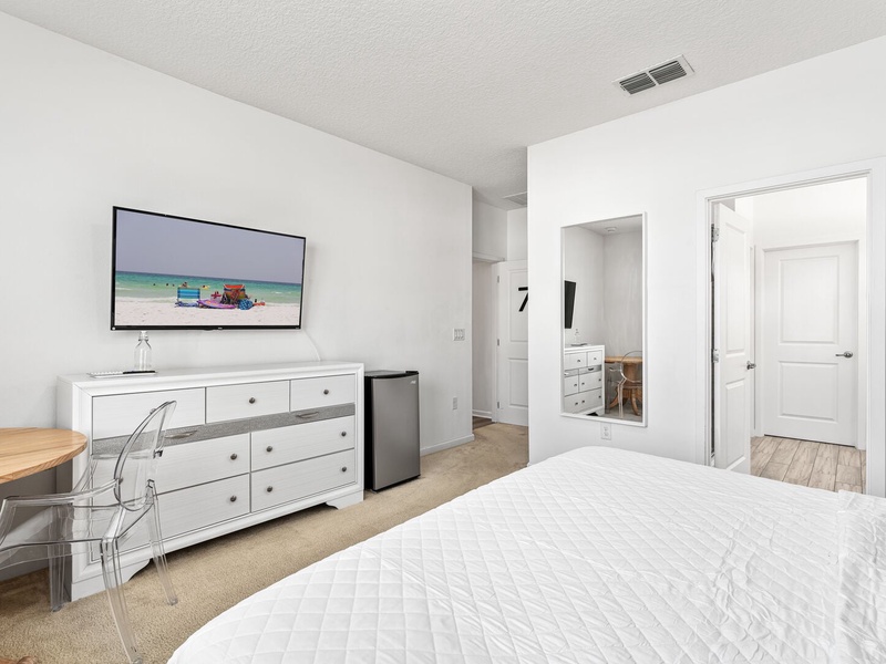 Our seventh bedroom features its own mini bar fridge, TV, working space, and full private bathroom.