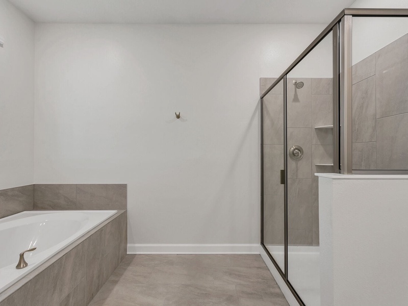 The master bathroom features a bathtub and shower.