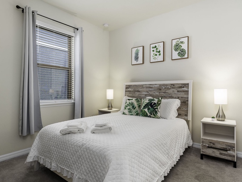 The first guest room on the first floor features a queen size bed, perfect for a restful night's sleep.