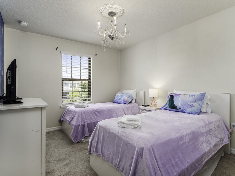 This guest room features two twin-sized beds and a full shared bathroom.