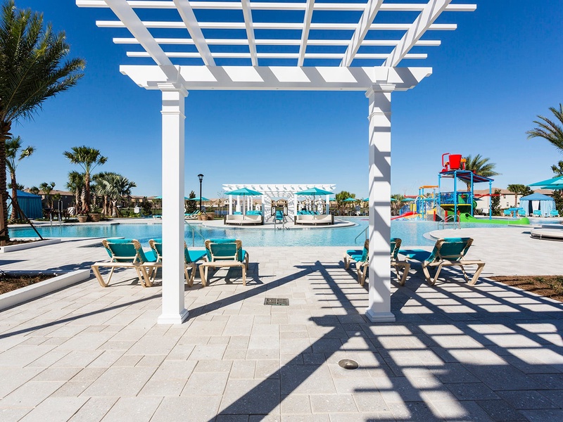 Windsor at Westside Resort features a beautiful expansive swimming pool with multiple lounge chairs and cabanas, perfect for basking in the sun.