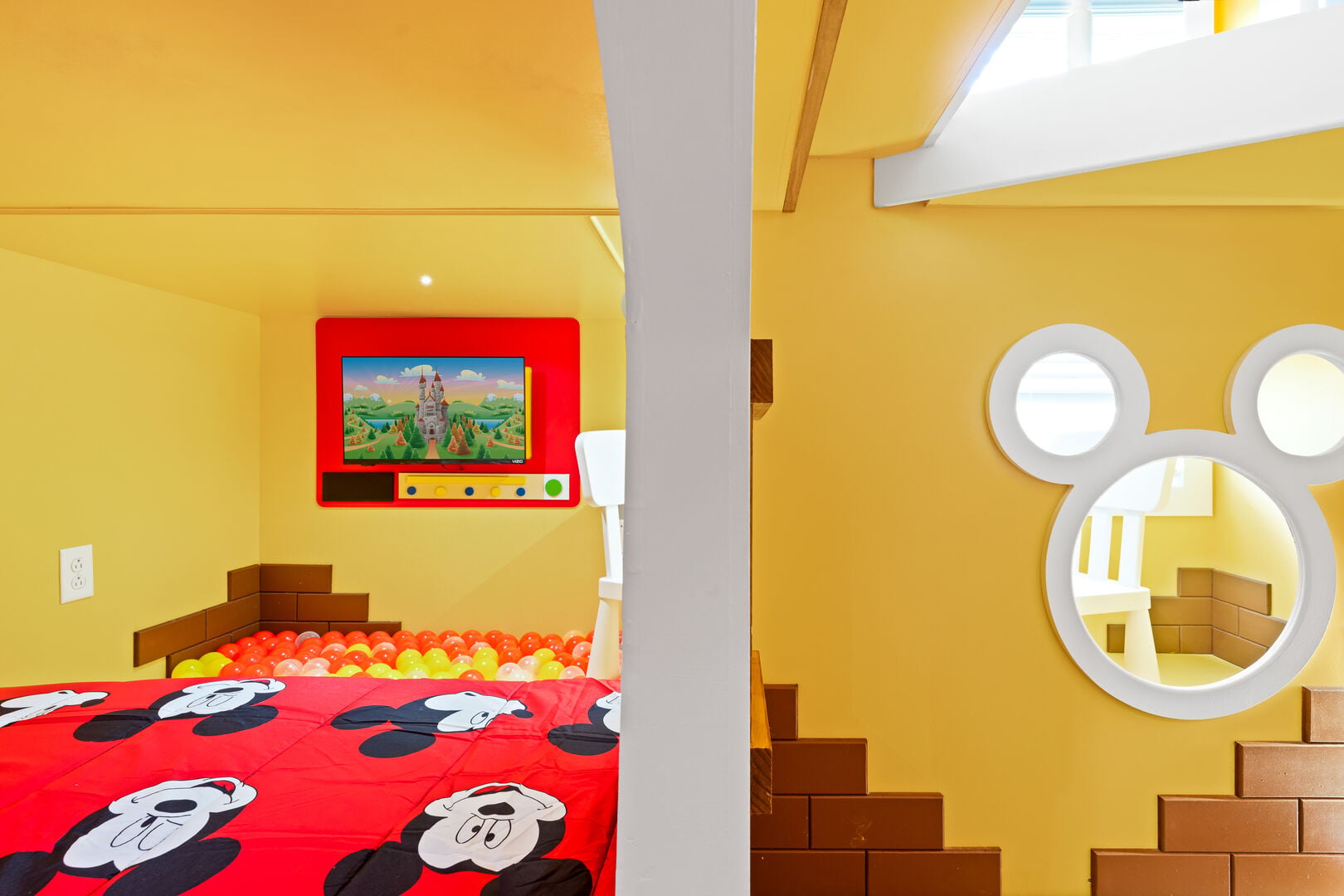 Our Mickey Mouse-themed room features a double-size bunk bed, a ball pit on the lower level, and a fun passage connecting to the upper-level rooms.