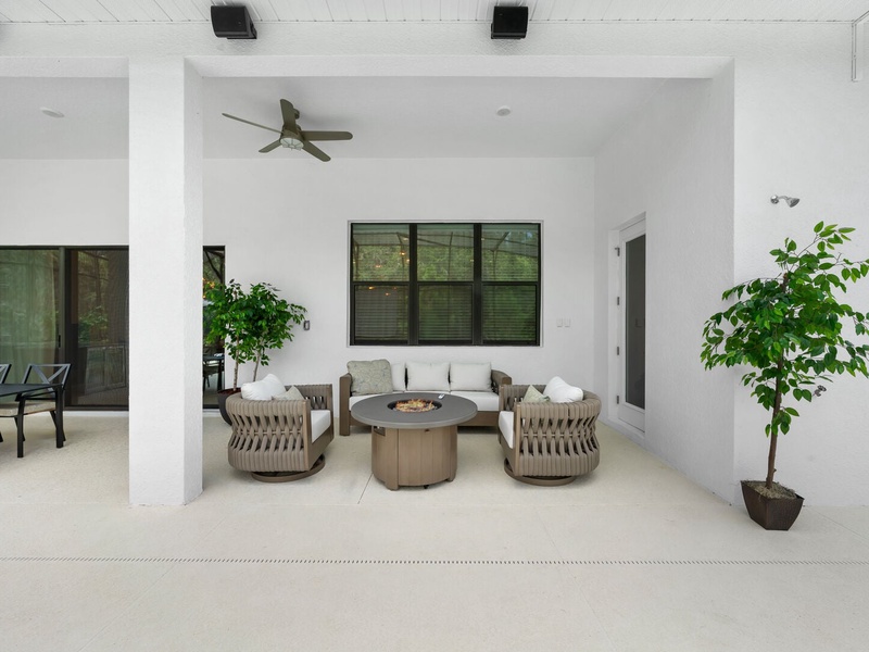 Relax in our charming outdoor living nook, featuring plush seating and a cozy fire pit at the center.