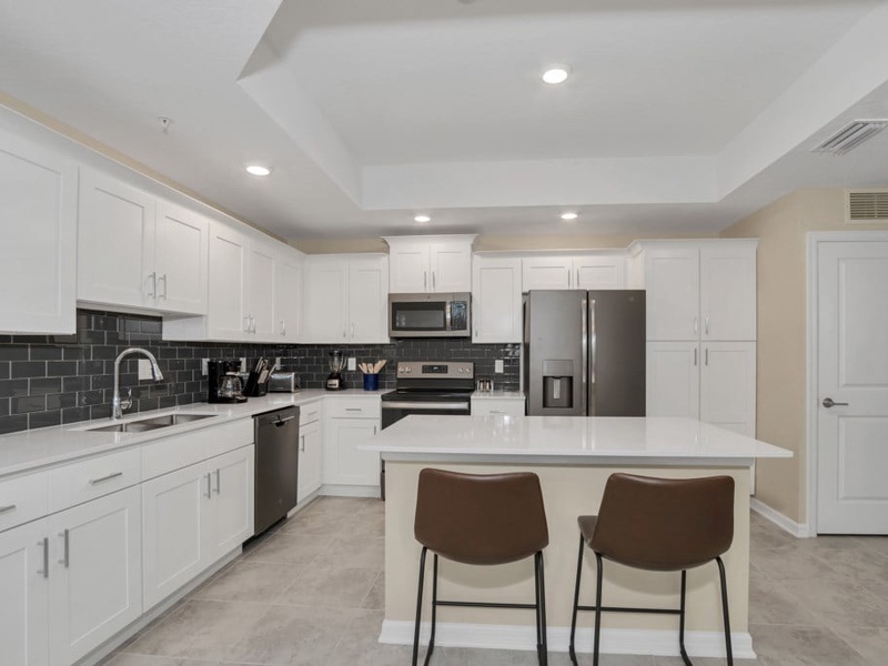 The kitchen features stainless steel appliances, granite counter tops and seating for 4 at the kitchen island.