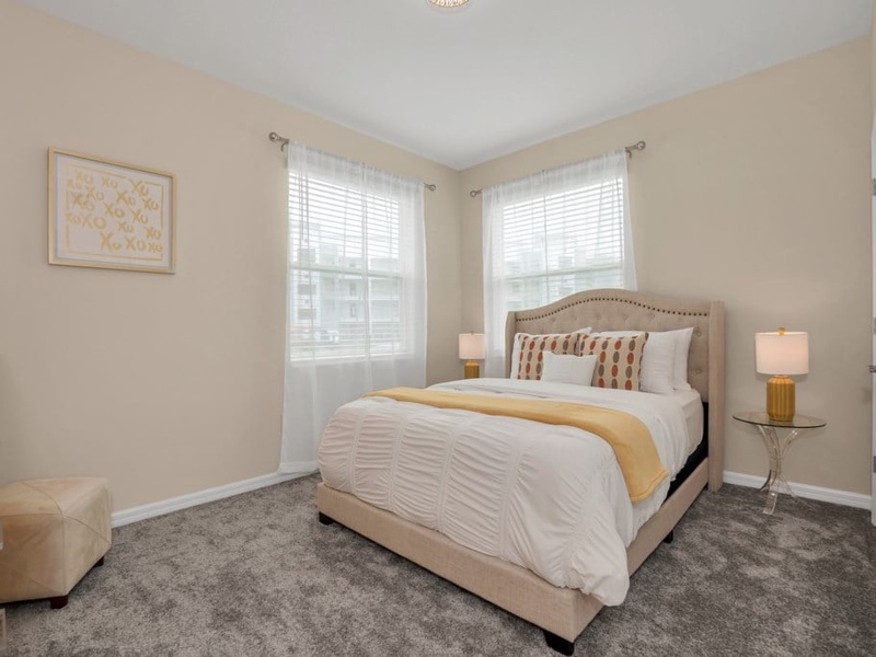 The second guest room features a queen bed, TV and access to a shared bathroom.
