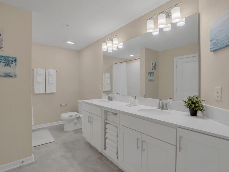 Spacious guest bathroom with a bathtub and double vanities.