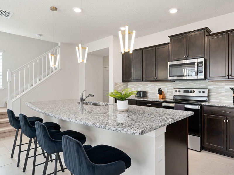 The kitchen area also integrates with the rest of the house, allowing easy interaction with guests in other living spaces.