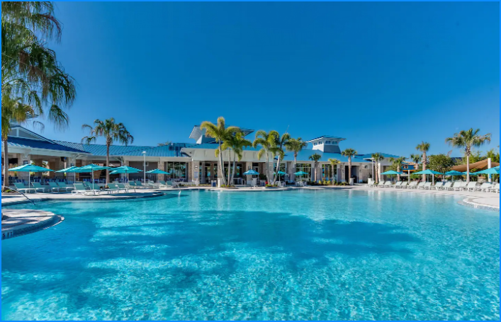 Windsor Island features a beautiful expansive swimming pool and a lazy river with multiple lounge chairs and cabanas, perfect for basking in the sun.