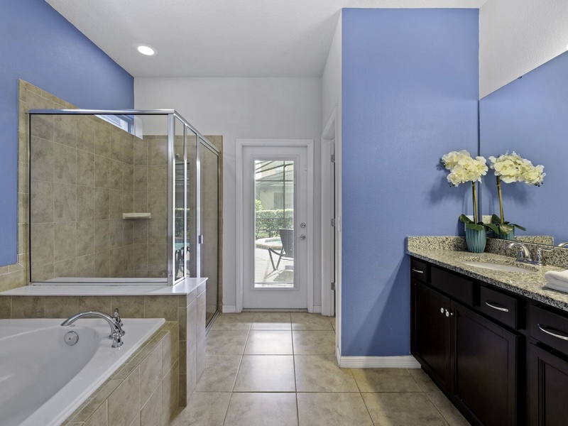 Our master bathroom features a shower, bathtub and access to the patio area.