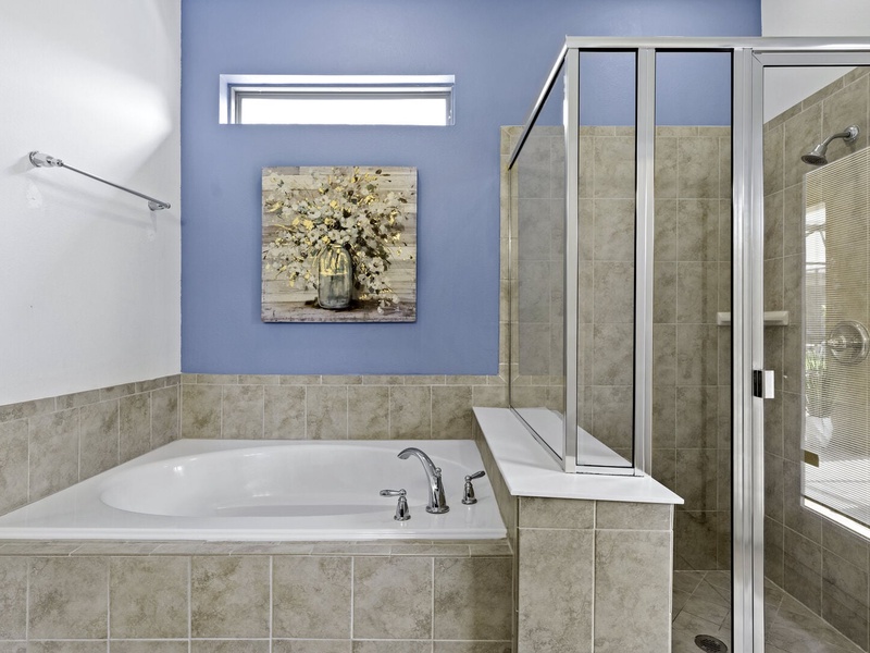 Our master bathroom features a shower, bathtub and access to the patio area.