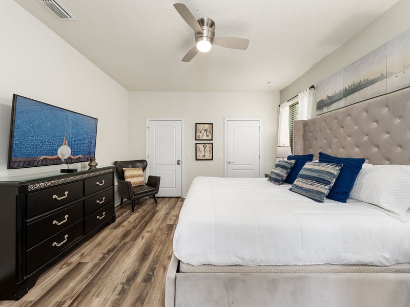 The second bedroom on the first floor features a king-size bed, a private bathroom, as well as access to the outdoor pool area.