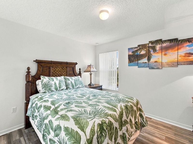 Spacious bedroom with comfortable bedding, dresser, and plenty of natural light.