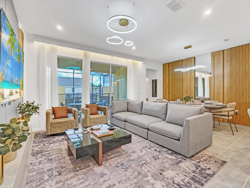 Unwind in this inviting living room featuring modern décor, plush seating, and views of the private pool.