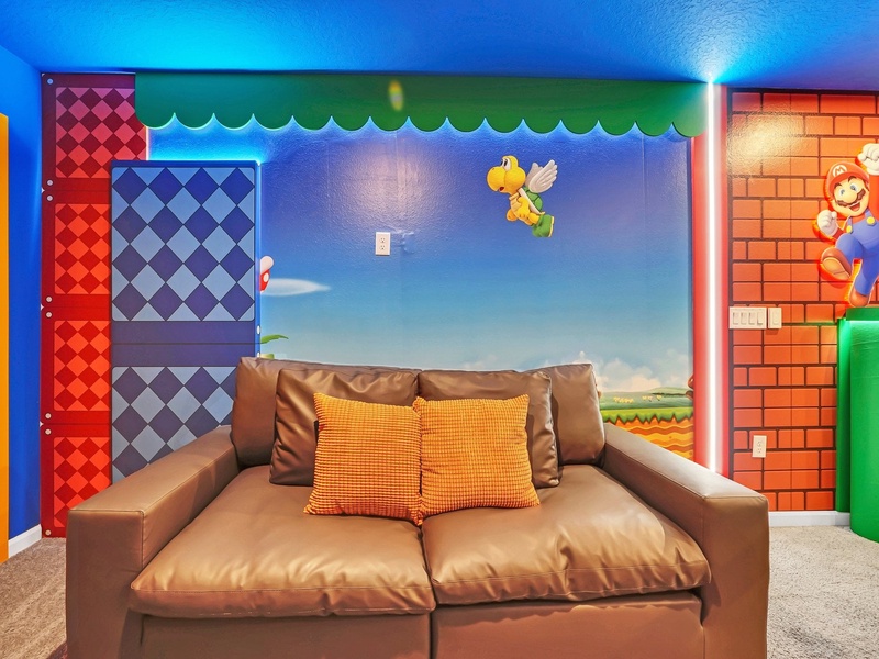 Level up your vacation in this vibrant Super Mario-themed living room with a cozy sofa and TV!