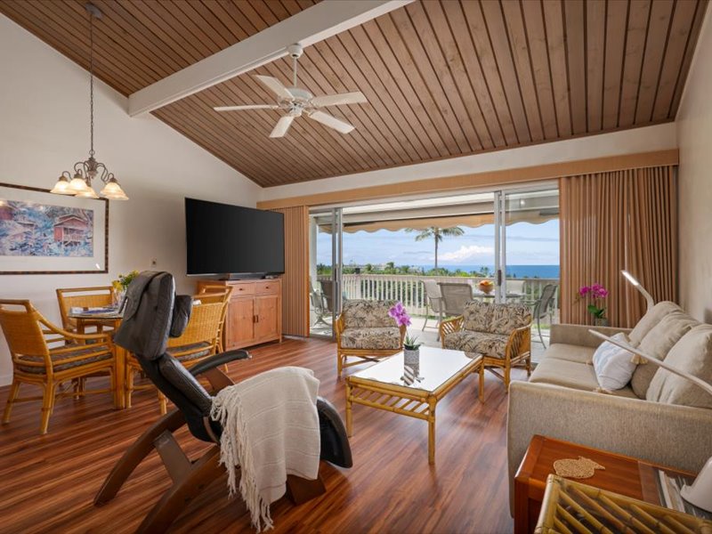 Enjoy stunning ocean views from this spacious open-concept living and dining area. Featuring vaulted ceilings, a large smart TV, and comfortable seating