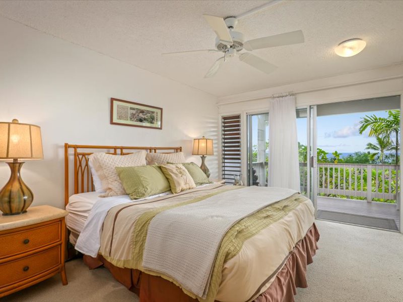 Wake up to gentle breezes and ocean views from this serene primary bedroom