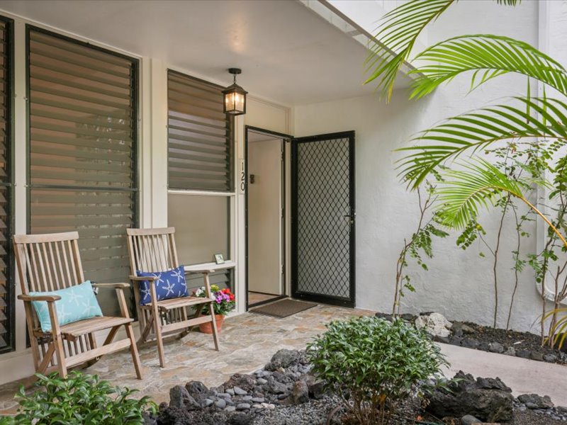 Arrive in style at this inviting front entry, surrounded by lush tropical greenery and lava rock accents