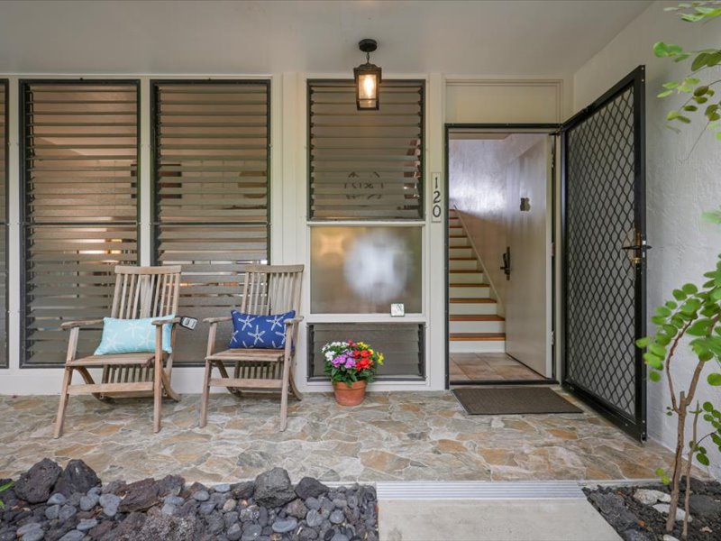 Welcome to your island retreat! The front entry features a charming stone walkway, cozy seating, and tropical accents that set a warm, welcoming tone