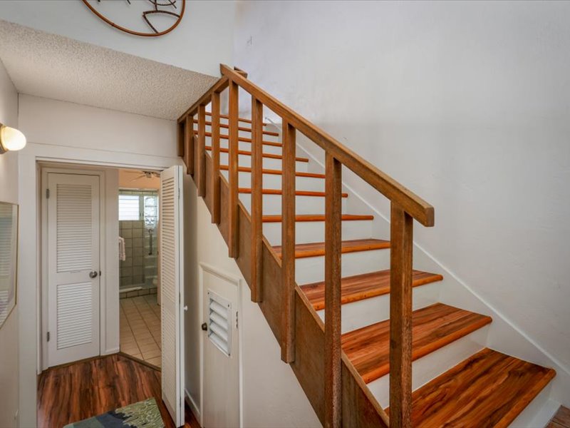 This welcoming entryway features beautiful hardwood stairs and a bright, open layout that leads to the main living areas above