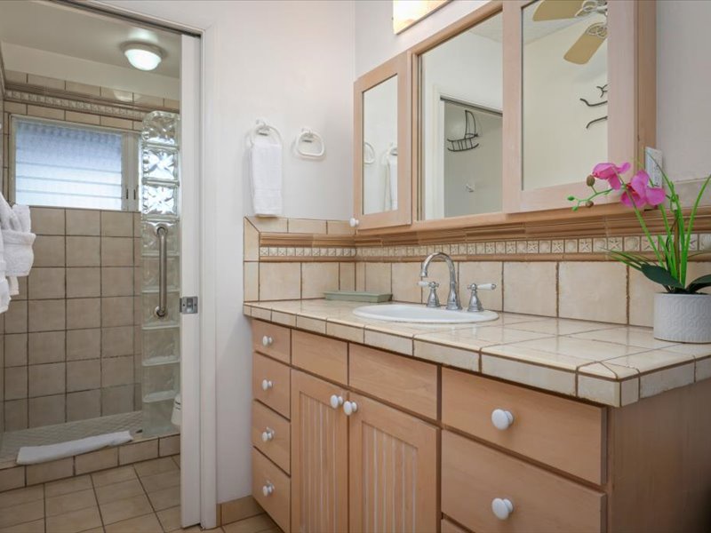 The primary bathroom features a clean, inviting design with warm tile finishes