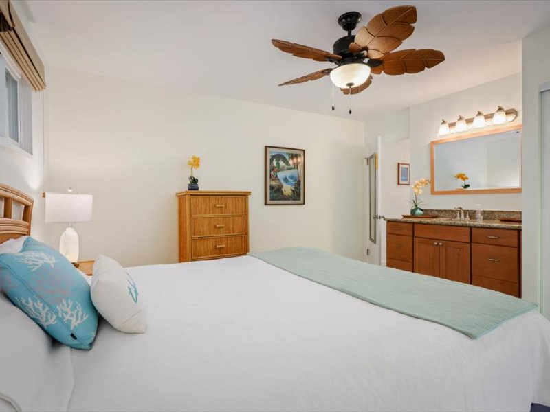 Spacious bedroom with coastal décor, a king bed, and an ensuite vanity area for added comfort and convenience.
