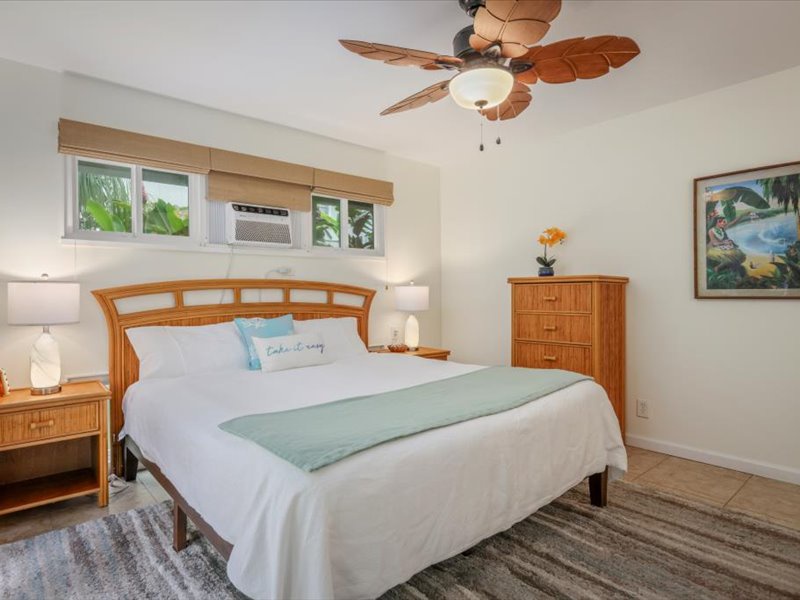 Inviting bedroom with tropical charm, featuring a king bed, island-style furnishings, and soft natural light for a relaxing retreat.
