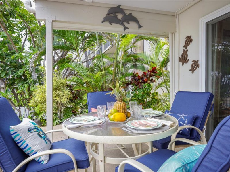 Charming lanai dining surrounded by tropical greenery, perfect for enjoying outdoor meals and island breezes.