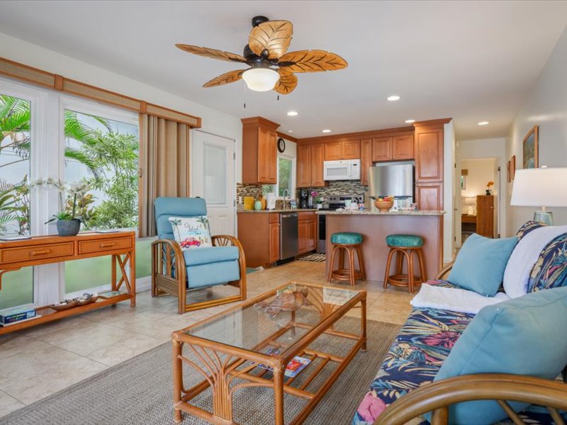 Inviting open-concept living space with tropical décor, comfortable seating, and a modern kitchen perfect for island living.