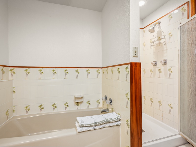 Unwind after your island adventures with a relaxing soak or a refreshing rinse—this spacious bathroom features both a walk-in shower and a full-size tub with fun tropical tile accents