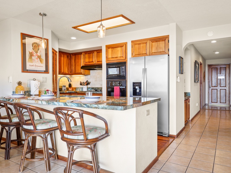 Cook in comfort in this beautifully appointed kitchen featuring granite countertops, stainless steel appliances, and island seating — perfect for casual meals or evening cocktails