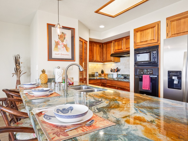 This vibrant kitchen features striking granite countertops, warm wood cabinetry, and a full suite of appliances. Bar seating makes it easy to gather, dine, or chat while cooking.