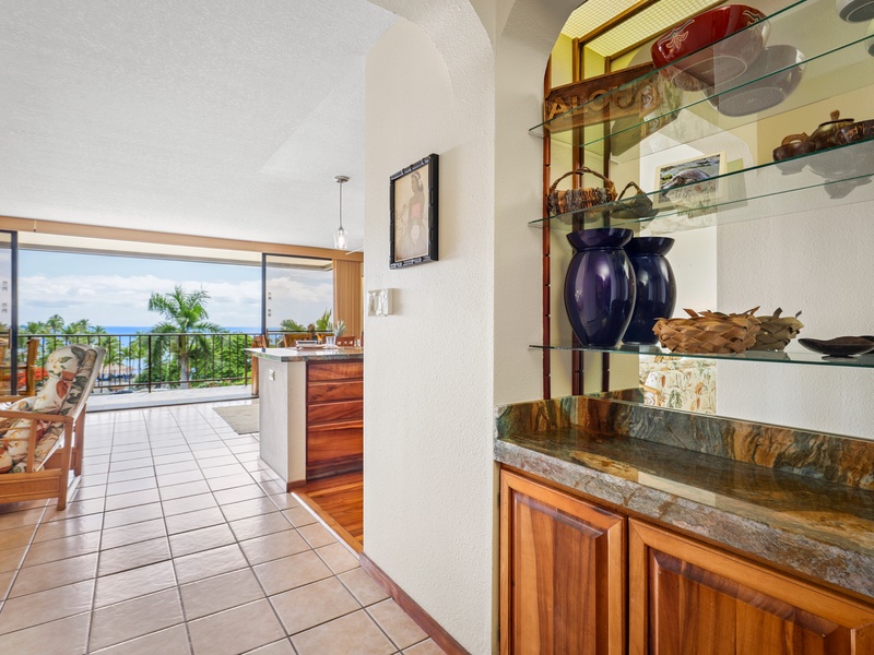 Tasteful Hawaiian decor and custom wood cabinetry welcome you into the open living space with panoramic ocean views from the moment you arrive
