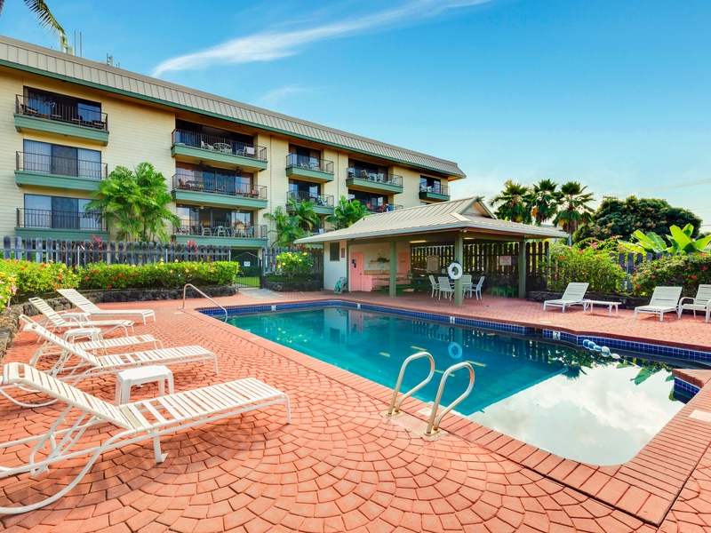 Soak up the sun or cool off with a refreshing swim in the beautifully maintained pool area, complete with lounge chairs, a shaded pavilion, and lush tropical landscaping—just steps from your condo