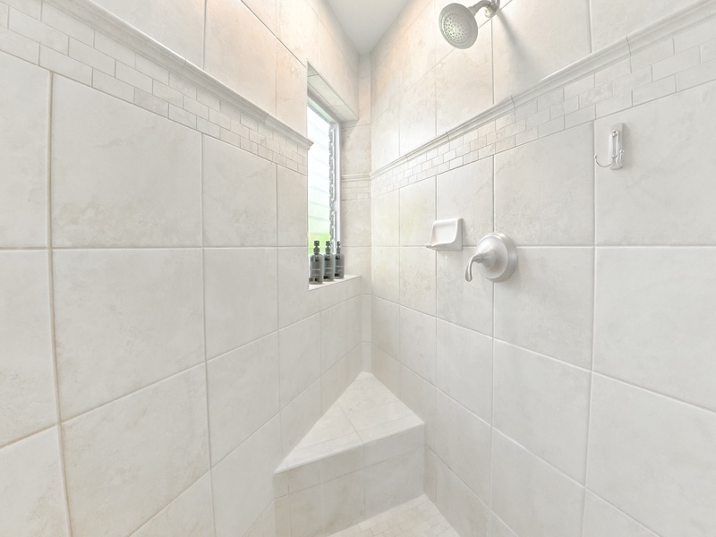 The walk-in shower has a rainfall showerhead, louvred window for letting the steam out after a hot rinse, and a corner bench seat for taking a rest or shaving your legs!