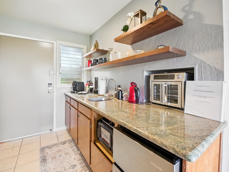 The entryway and kitchenette of unit 131. Coffee maker is included, as well as a few packs of complimentary coffee grounds!
