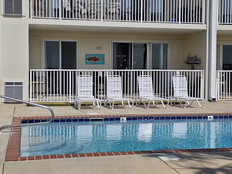 view of pool chairs & balcony