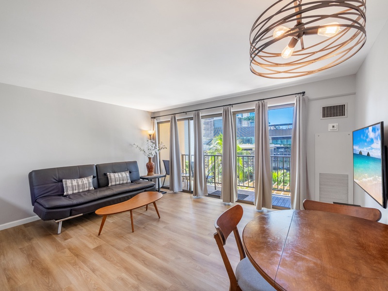 Unwind in a spacious living room with a futon sleeper, smart TV, and floor-to-ceiling windows leading to your private lanai.