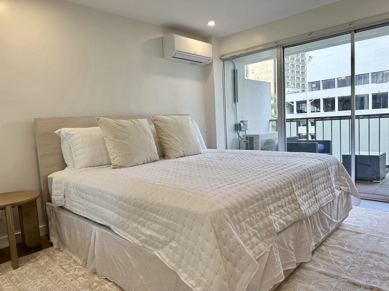 Bedroom with king bed smart TV mirror closet doors AC balcony