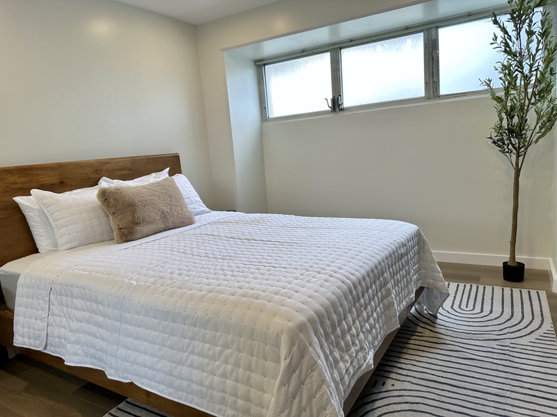 Bedroom with queen bed mirror closet doors and AC