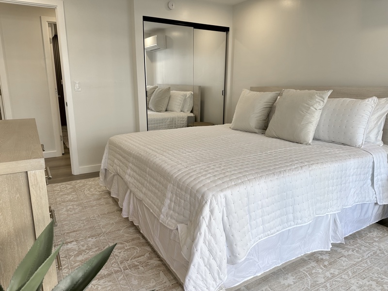 Bedroom with king bed smart TV mirror closet doors AC balcony