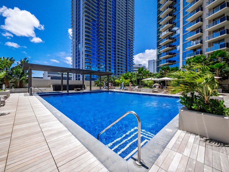 Dive into island living with sweeping pool views and lush palms. After a swim, retreat to your private lanai and enjoy secure access to a lap pool, hot tub, and playground.