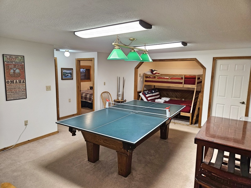 Downstairs game room with bunks and queen beyond