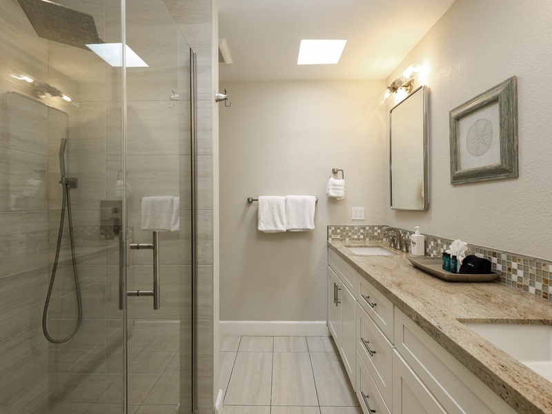 Beautifully remodeled primary bathroom includes two sinks and a walk-in shower