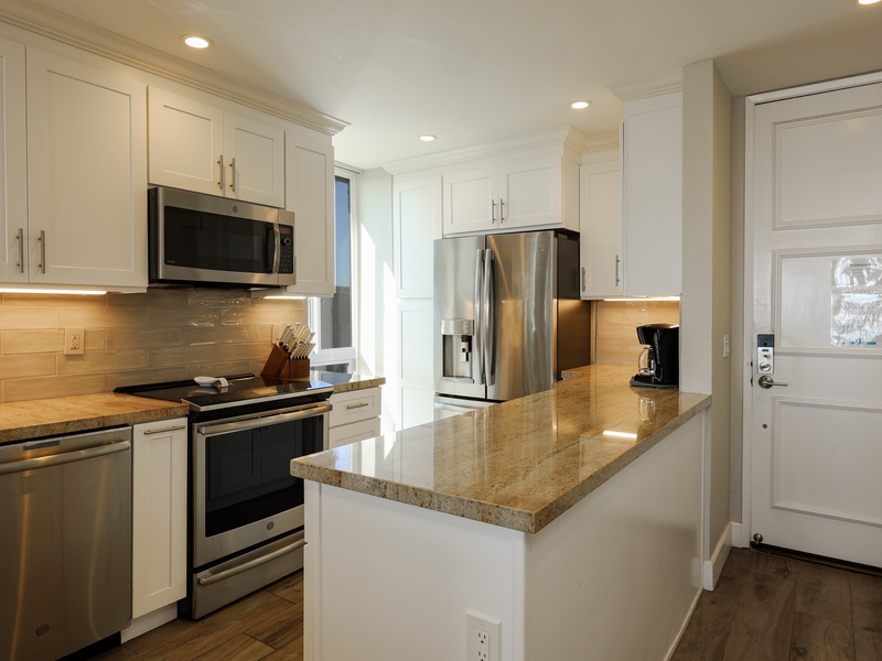 Remodeled kitchen is furnished with dinnerware, cookware, and of course a coffee maker