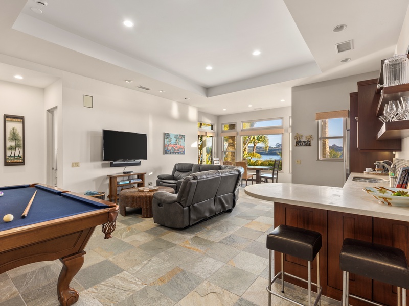Lower level family room featuring, a kitchen, pool table, entertainment area, and spacious bathroom. 