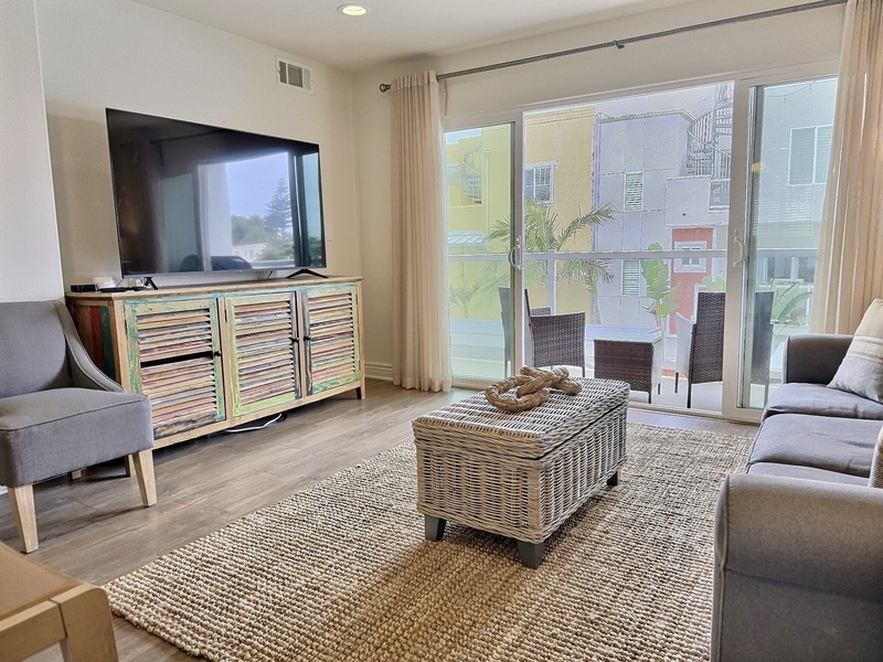 The bright, airy living room opens to a private balcony with a natural gas BBQ. The balcony seating offers the perfect spot to relax and enjoy the coastal breeze.