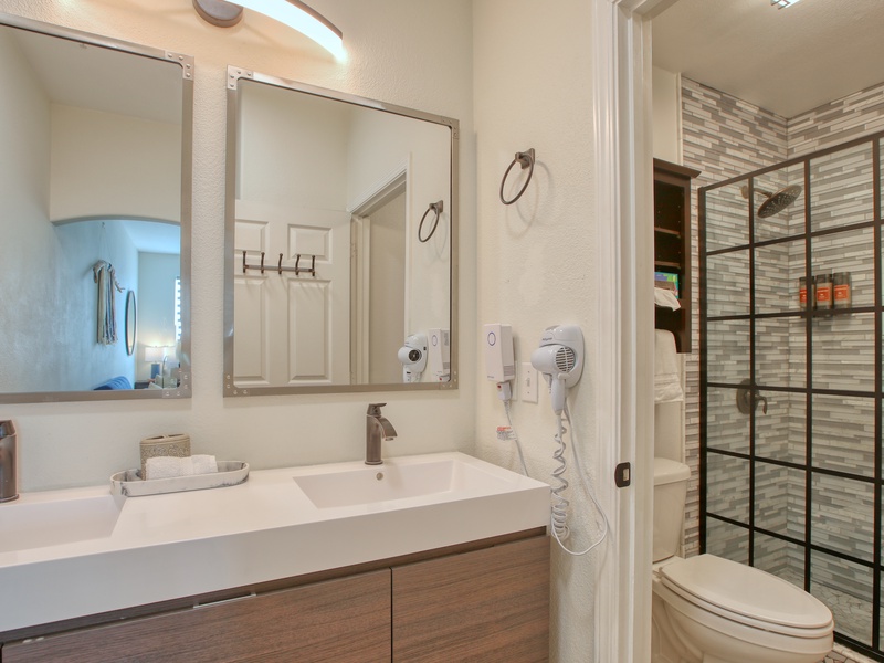 A sleek, modern bathroom featuring double sinks and a spacious walk-in shower for a touch of everyday luxury.