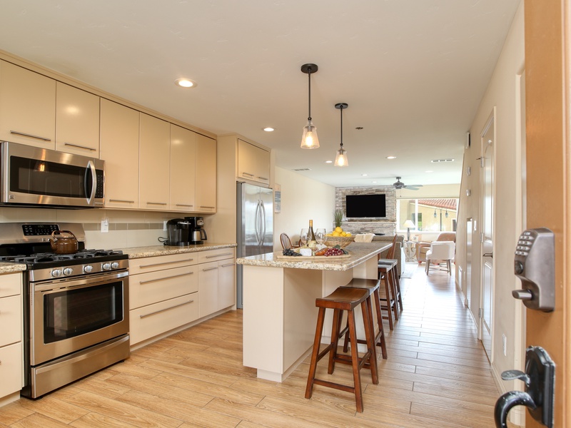The chef’s kitchen features high-end appliances, a long prep island with bar seating, and dining for six, perfect for entertaining or family meals.
